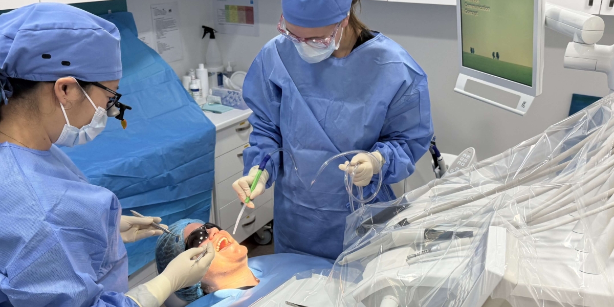 Two dentists performing procedure on patient