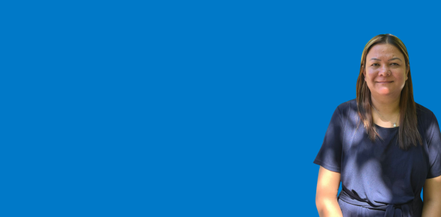 Person standing in blue background, right side