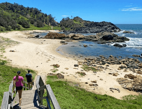 People on stairs to rocky beach