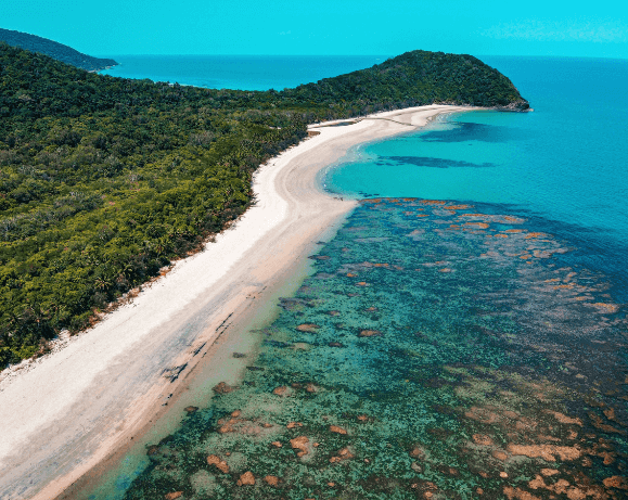 Curved tropical beach with reef and blue water