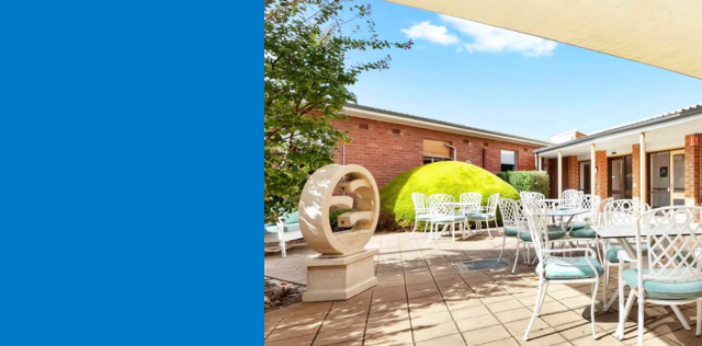 Outdoor courtyard with white seating and garden.