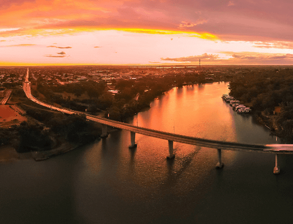 Bridge over river at glowing sunset