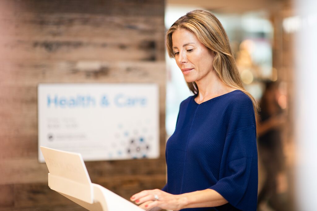 Person using a touchscreen kiosk in a care facility