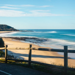 Coastal road, fence sandy beach and ocean view