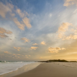 Sunset beach with gentle waves and clouds