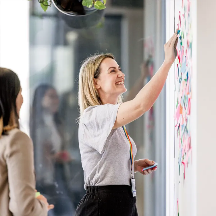 Person placing sticky notes on wall