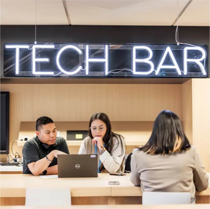 Team collaborating at shared tech bar