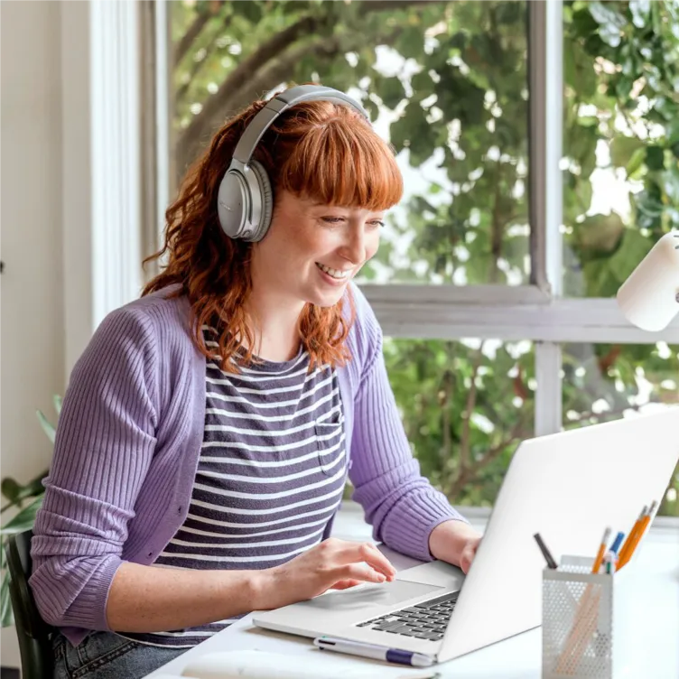 Person working on laptop with headphones