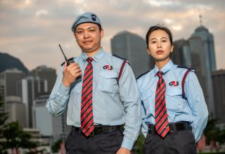 Two uniformed security guards in city background