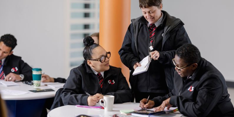 People in uniforms working together at tables in a collaborative environment.