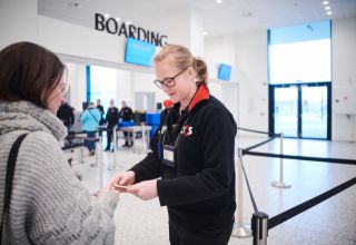 Security staff checks ID at airport boarding area.