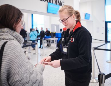 Security staff checks ID at airport boarding area.