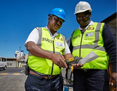 Two workers in safety gear inspecting equipment.