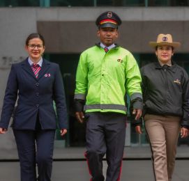 Security staff in uniform walking in front of building.