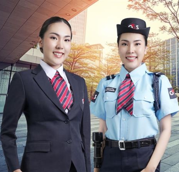 Two security staff standing and smiling in hallway.