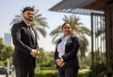 Two professionals standing outside in formal attire.