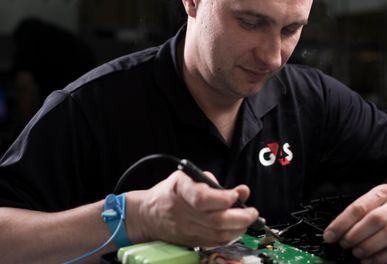 Man repairing electronic device with soldering tool.