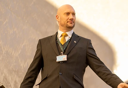 Man in suit with access pass walking down stairs