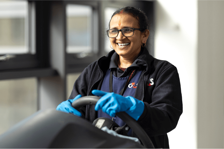 G4S employee using a ride on floor cleaner