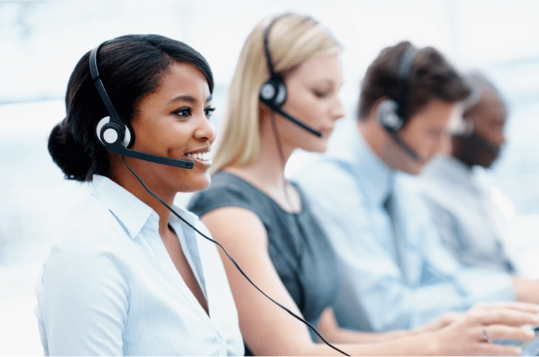 Four people with headphones typing on computer