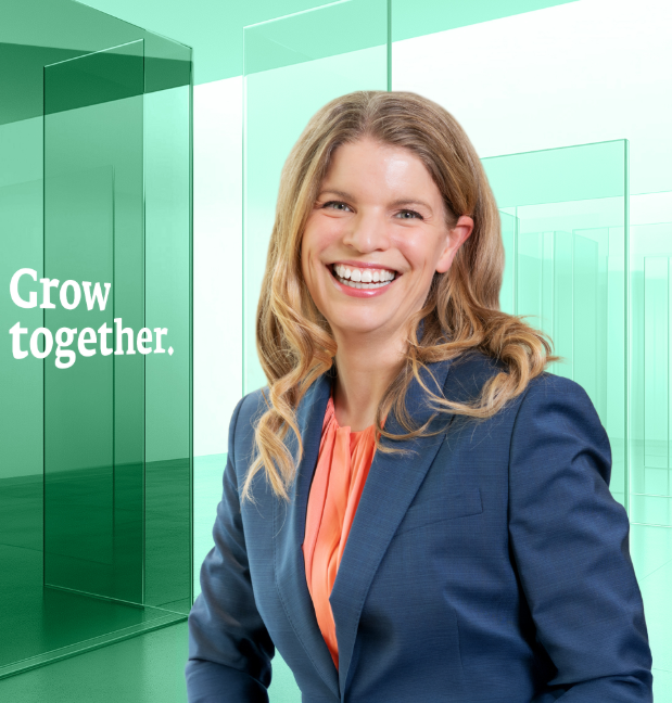 Lächelnde Frau im Anzug mit Text „Grow together“