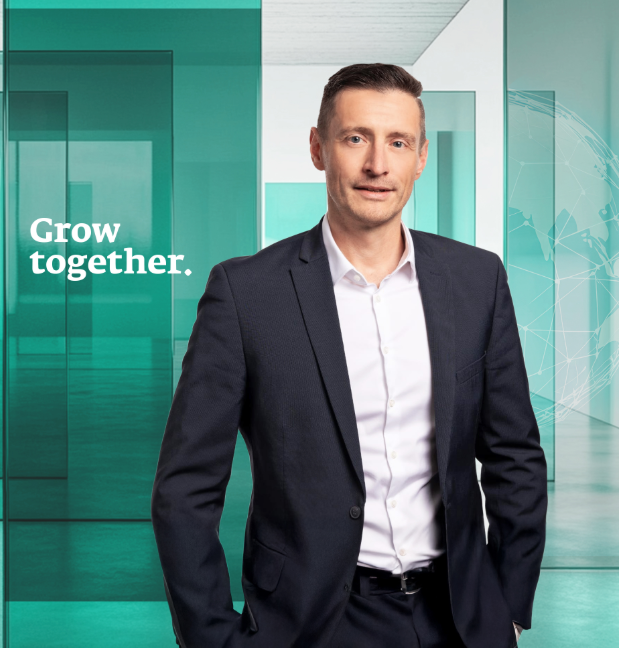 Mann im Anzug mit Text „Grow together“ im Hintergrund