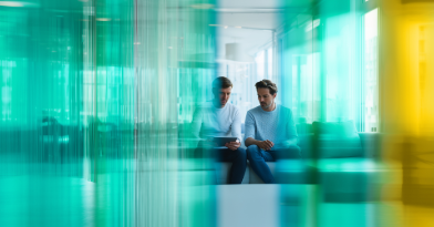 Zwei Männer sitzen im Büro und unterhalten sich.