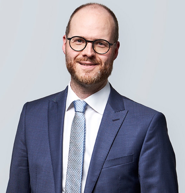 Smiling man in blue suit and glasses