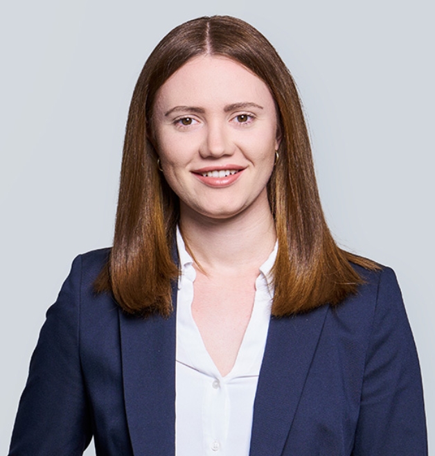 Smiling woman in business attire against grey backdrop