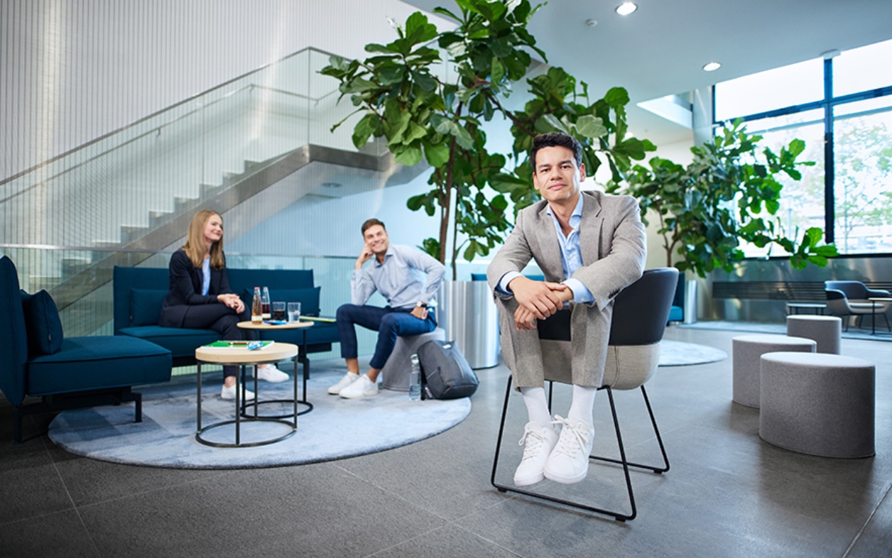 Three people chatting in a modern office lounge area