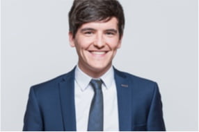 A man smiling in a navy blue suit