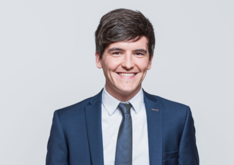 A man smiling in a navy blue suit