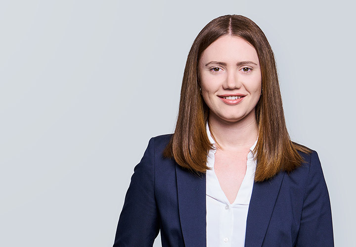 Smiling woman in business attire against grey backdrop