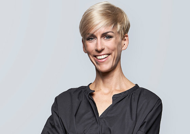 Smiling woman with short blond hair in dark top