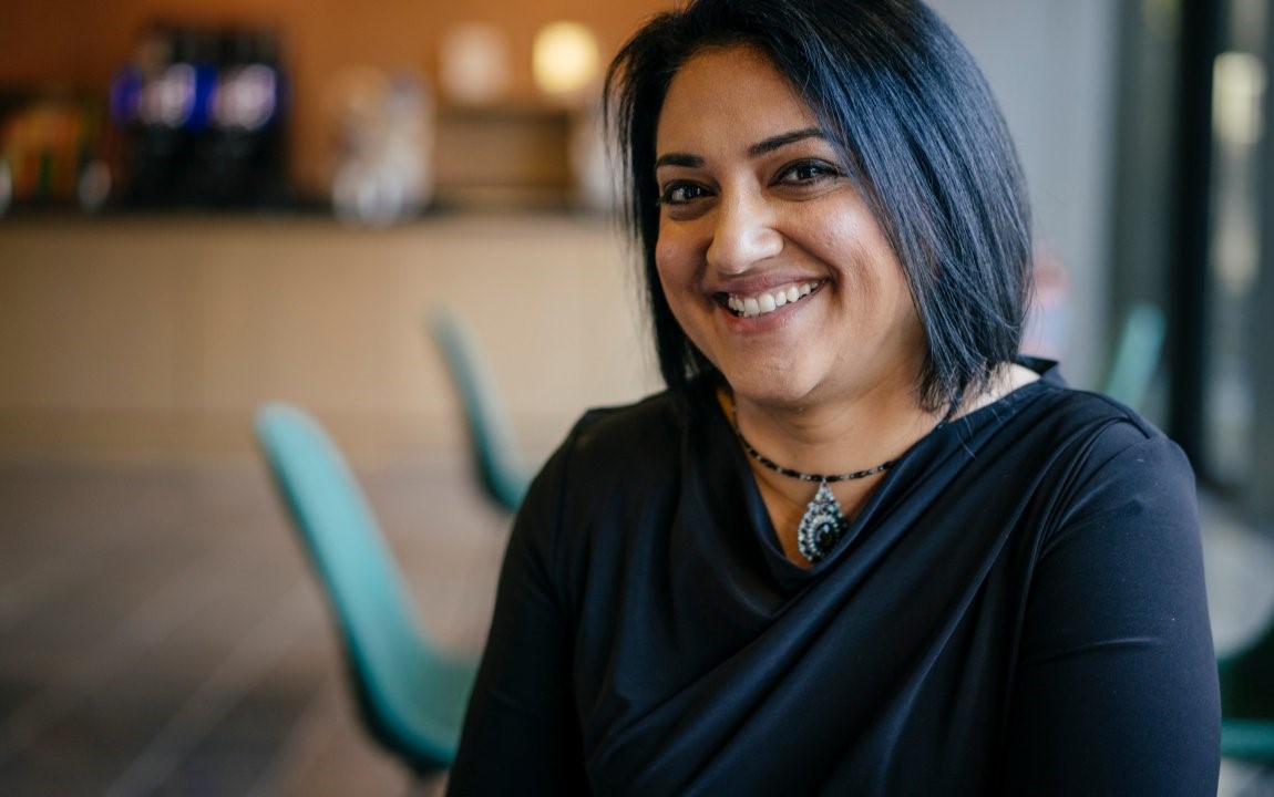 Smiling woman in an office cafeteria.