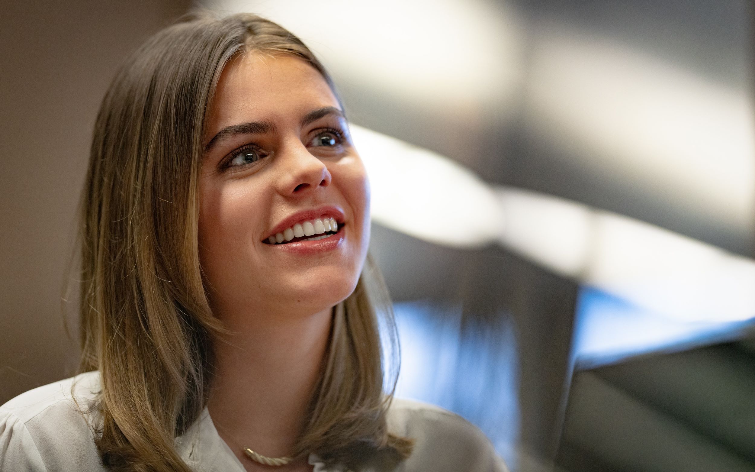 Young women smiling, not looking directly into the camera.