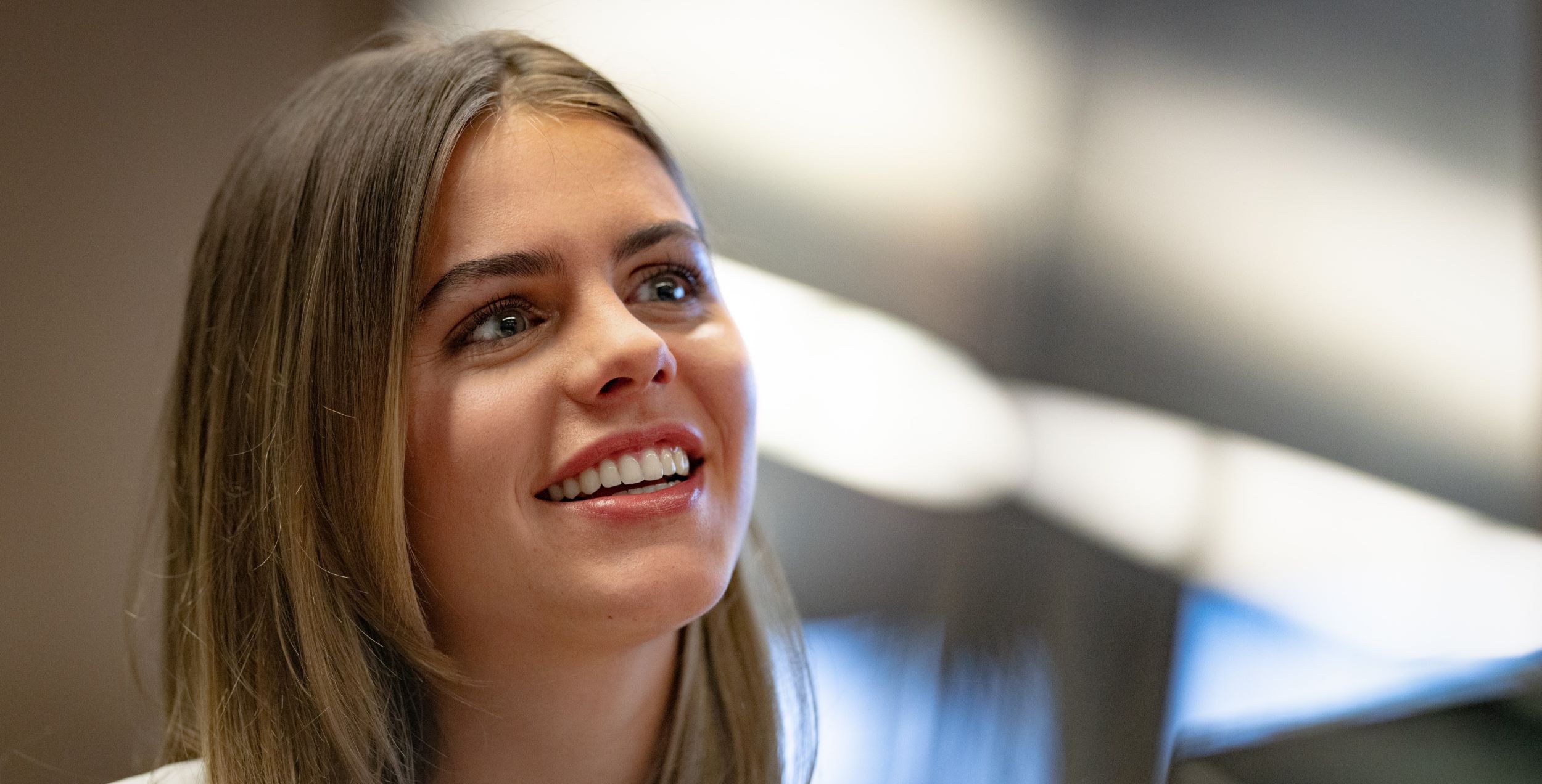 Young woman smiling to someone not in sight.