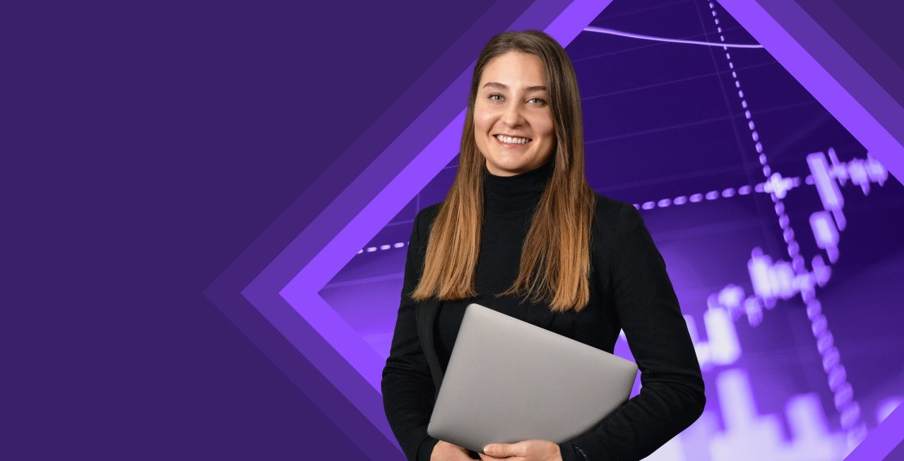Young woman smiling with laptop under her arm in front of a tech background.