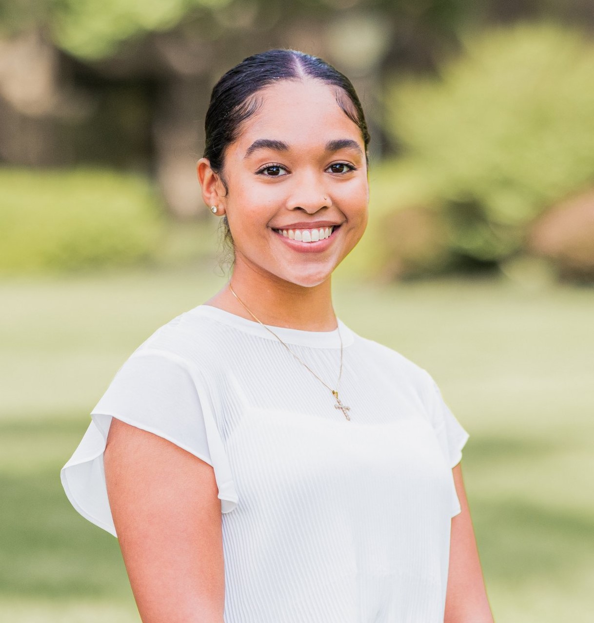 Young smiling woman in a park, smiling to the camera