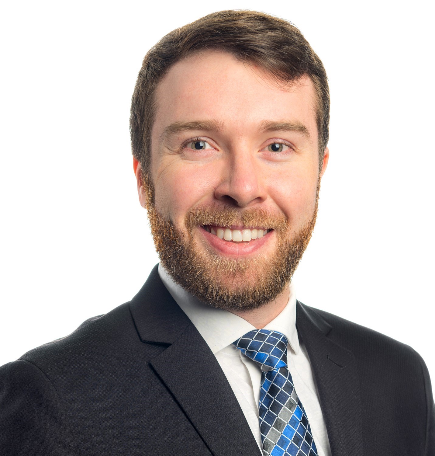 Portrait foto of a young man with a beard, wearing suit and tie.