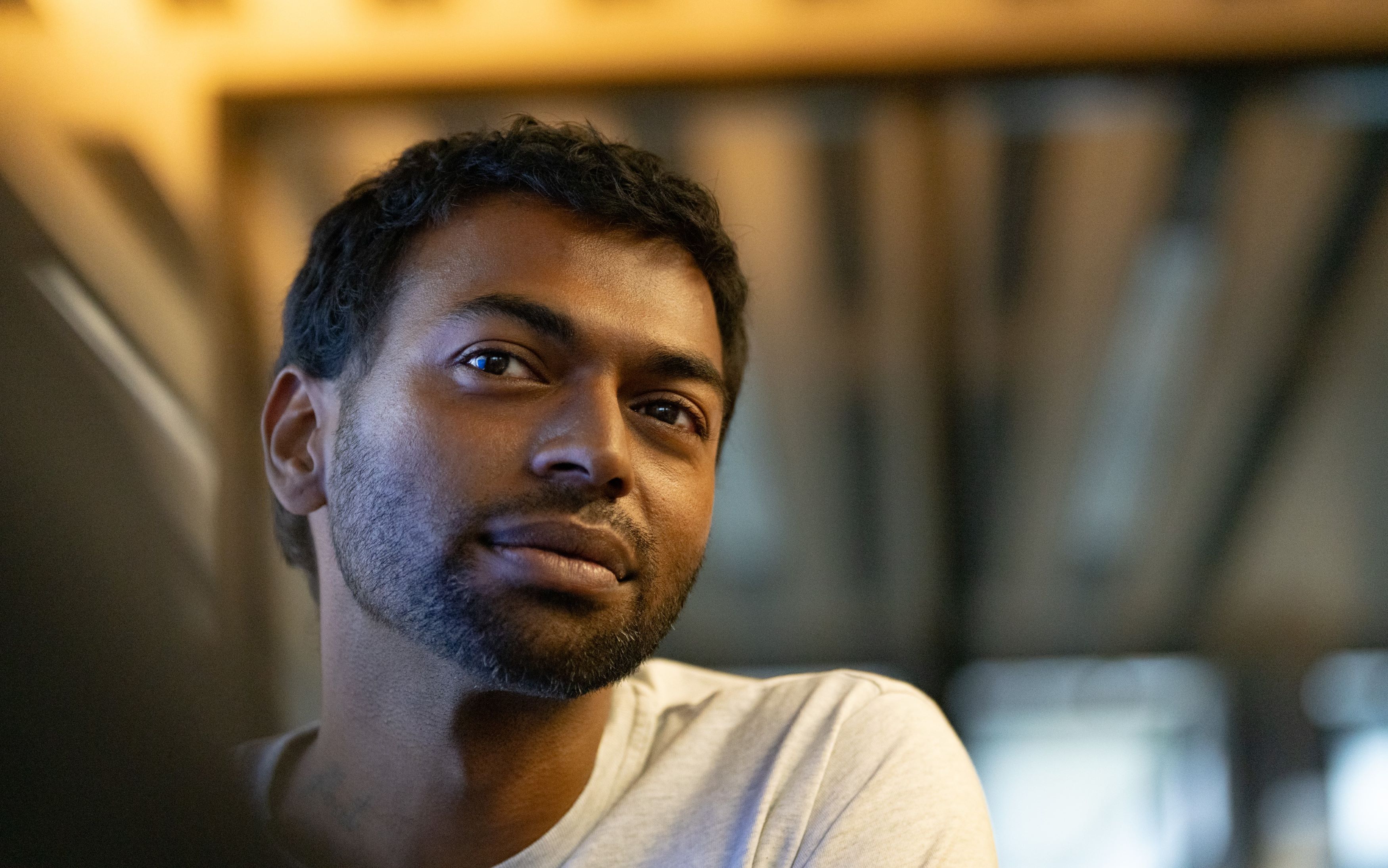Young man in a white shirt looking friendly into the camera.