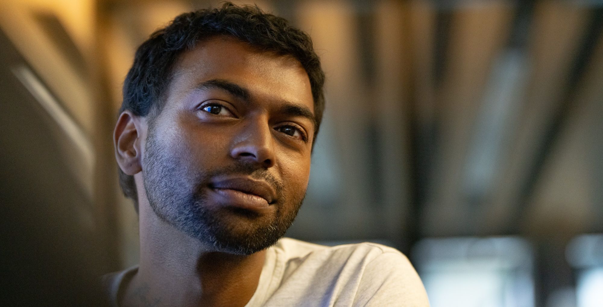 Young man in a white shirt looking friendly into the camera.