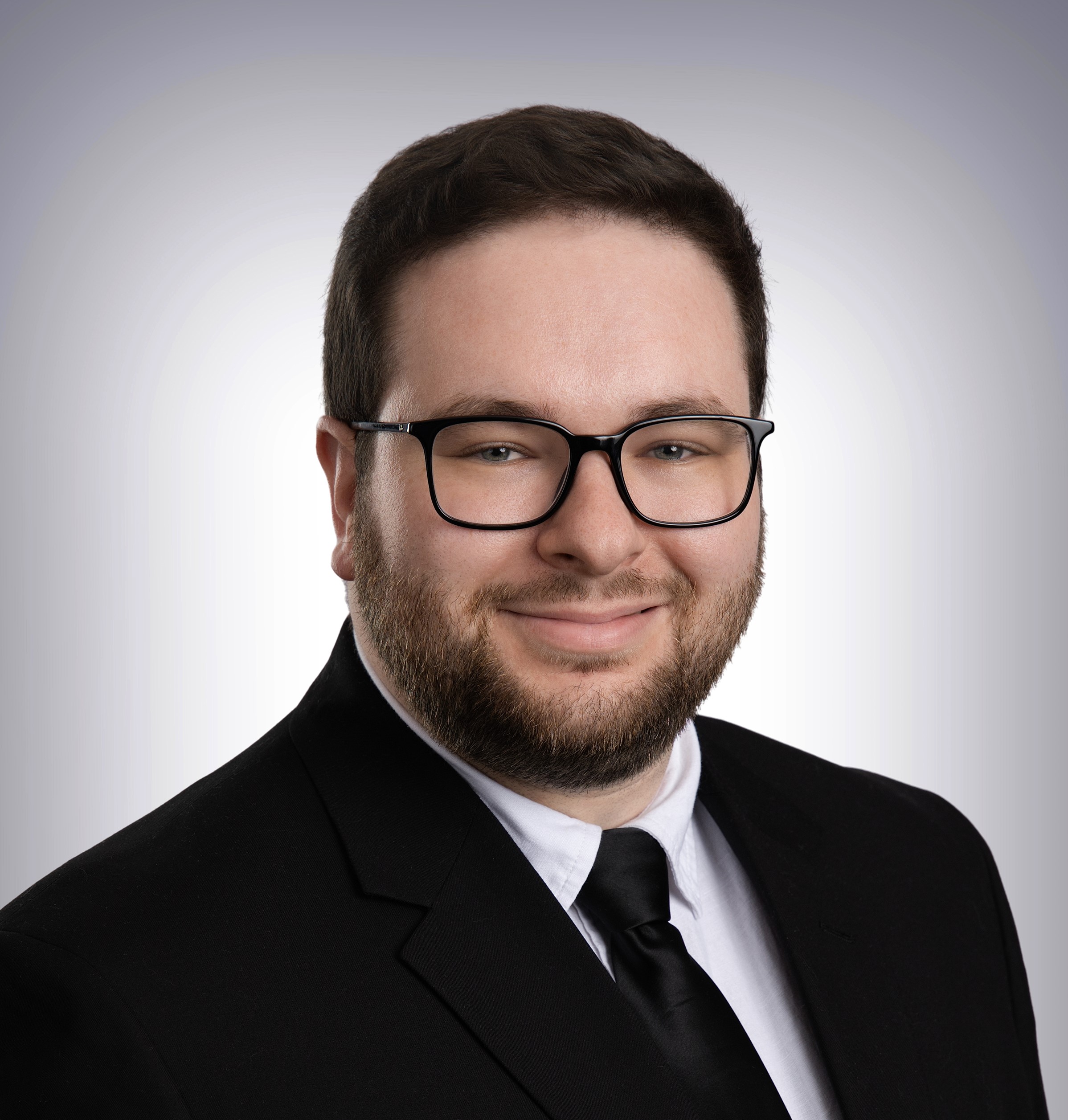 Portrait photo of a bearded man in a suit, slightly smiling.