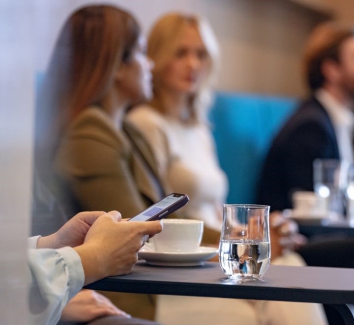 Person using phone during a meeting or event.