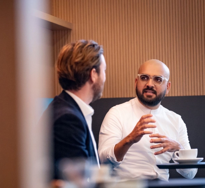 Two men having a focused conversation over coffee.