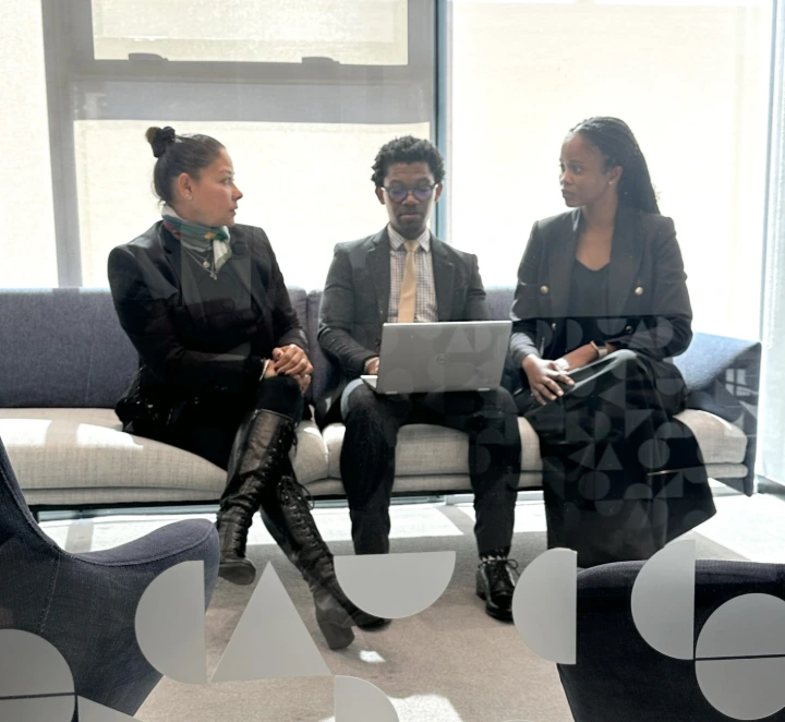 Team talking and sitting on sofa in office.