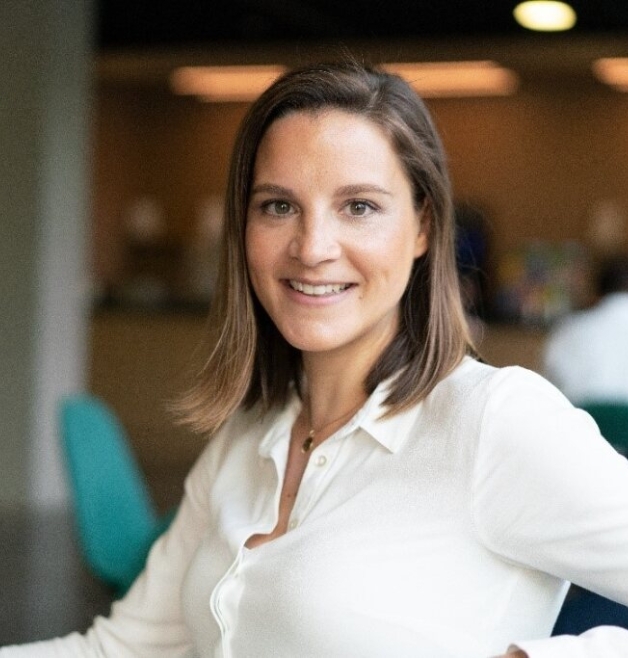 Woman smiling in office setting wearing white shirt