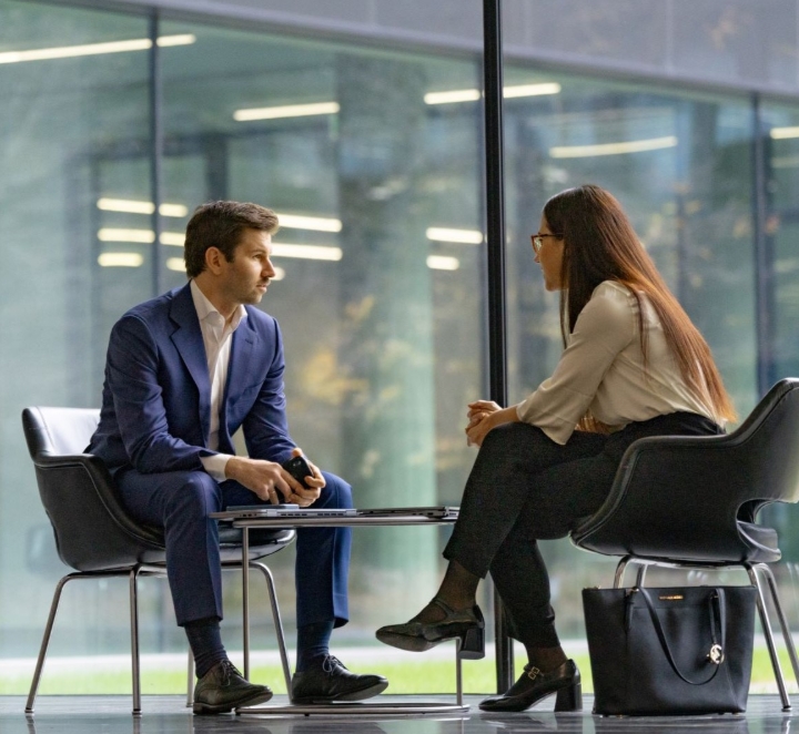 Two people talking in an office lobby.