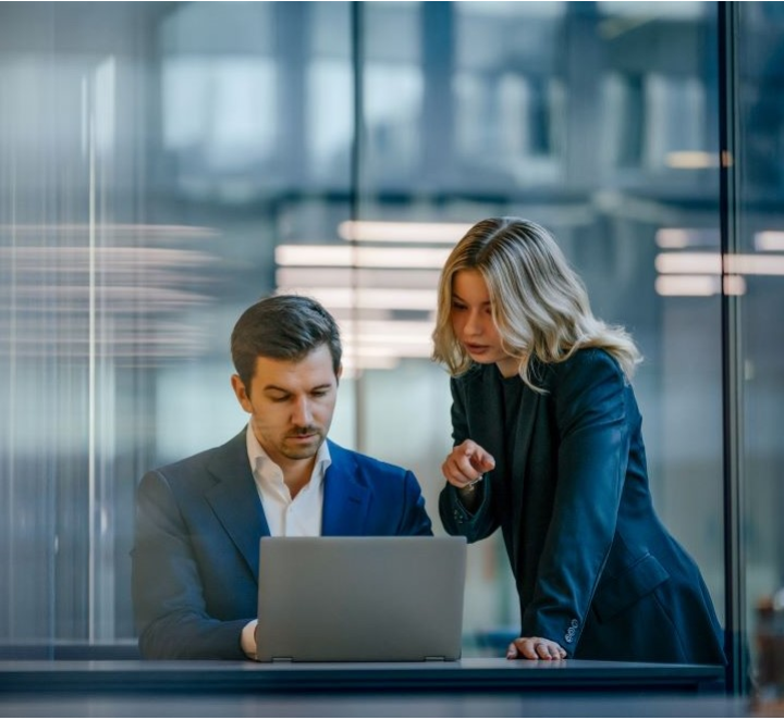 Two colleagues looking at a laptop together