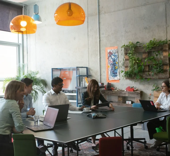 Teammeeting im modernen Büro mit Laptops